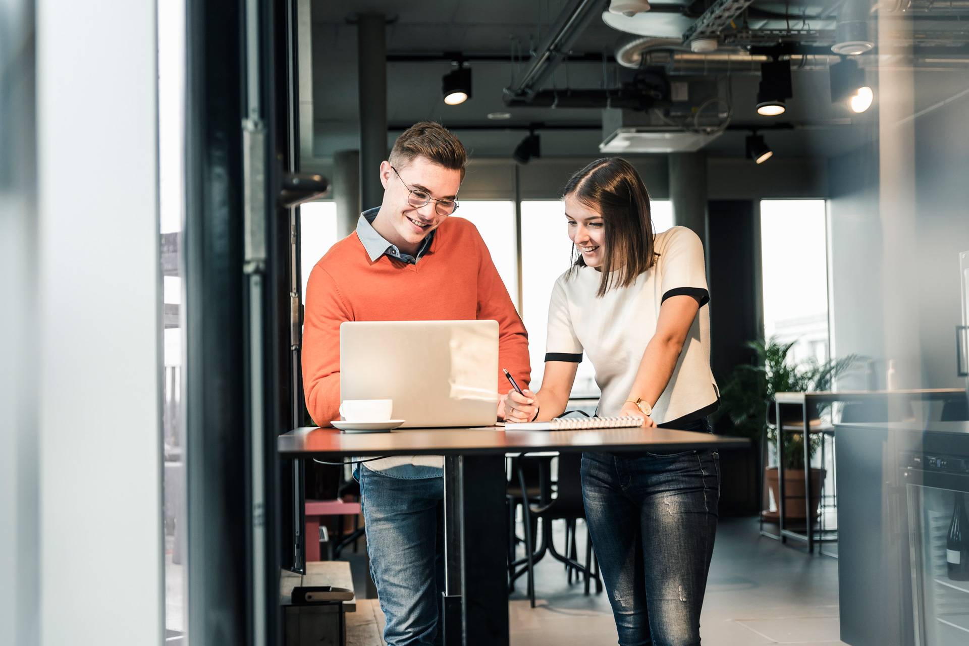 Two young business people working over a laptop